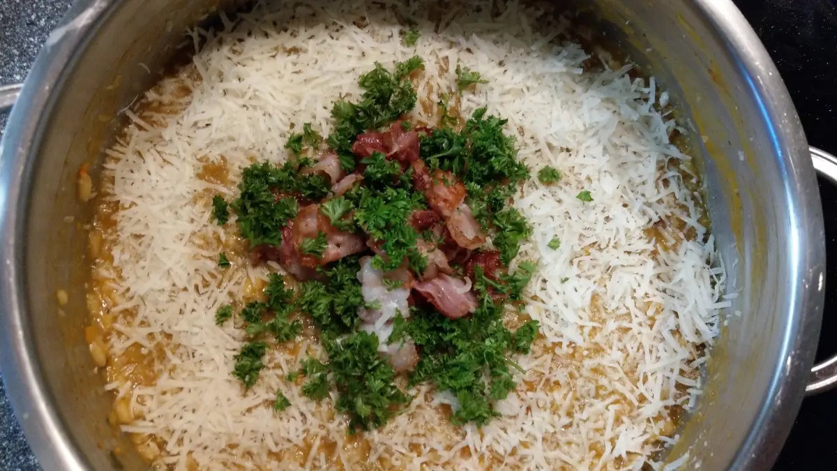 Kürbis Risotto im Topf angerichtet mit Speck und Parmesan